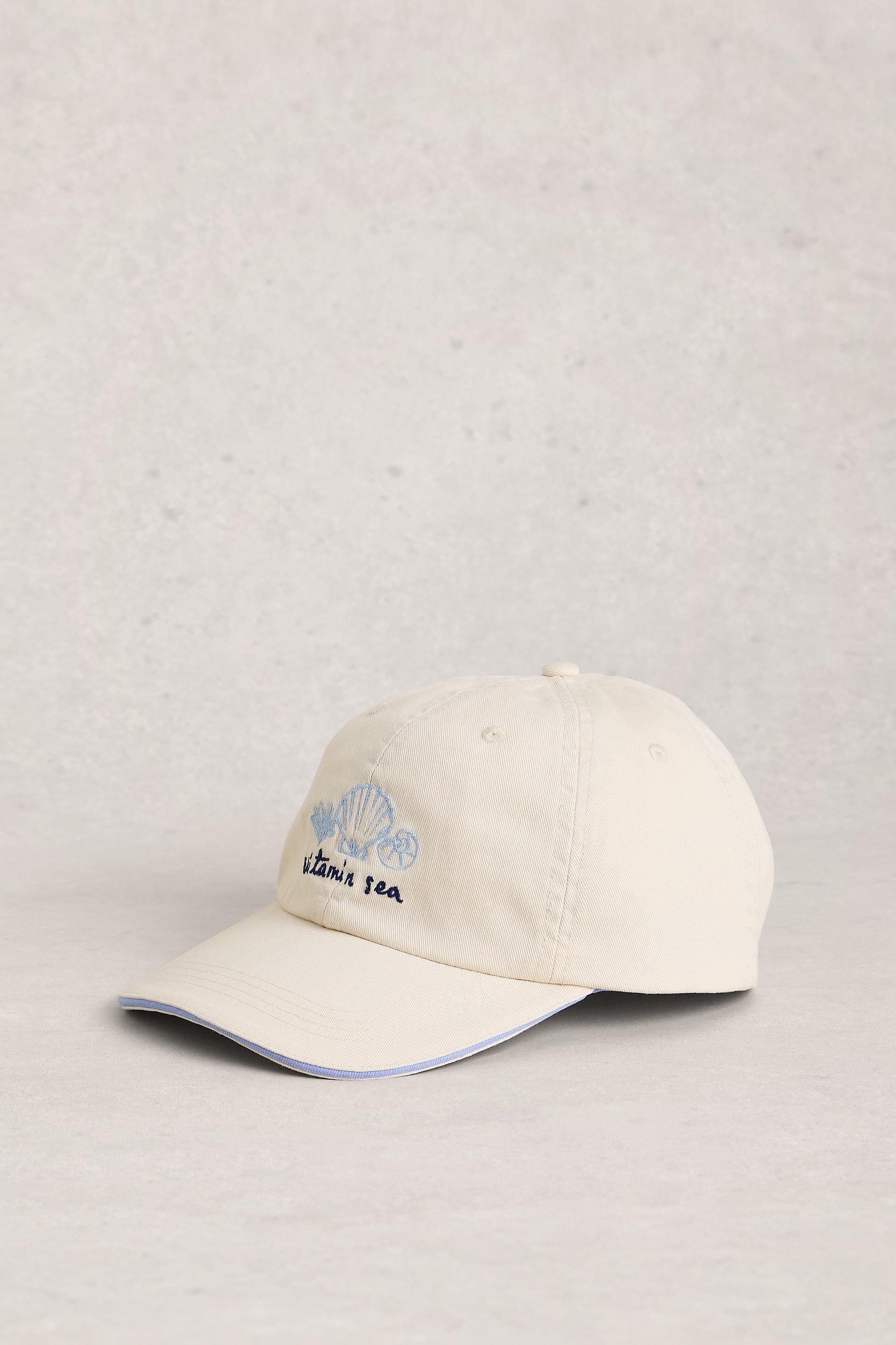 Beige cap with branding on a light gray background