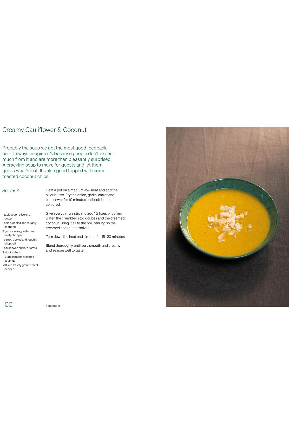 A bowl of creamy golden cauliflower and coconut soup garnished with toasted coconut flakes from a recipe book.