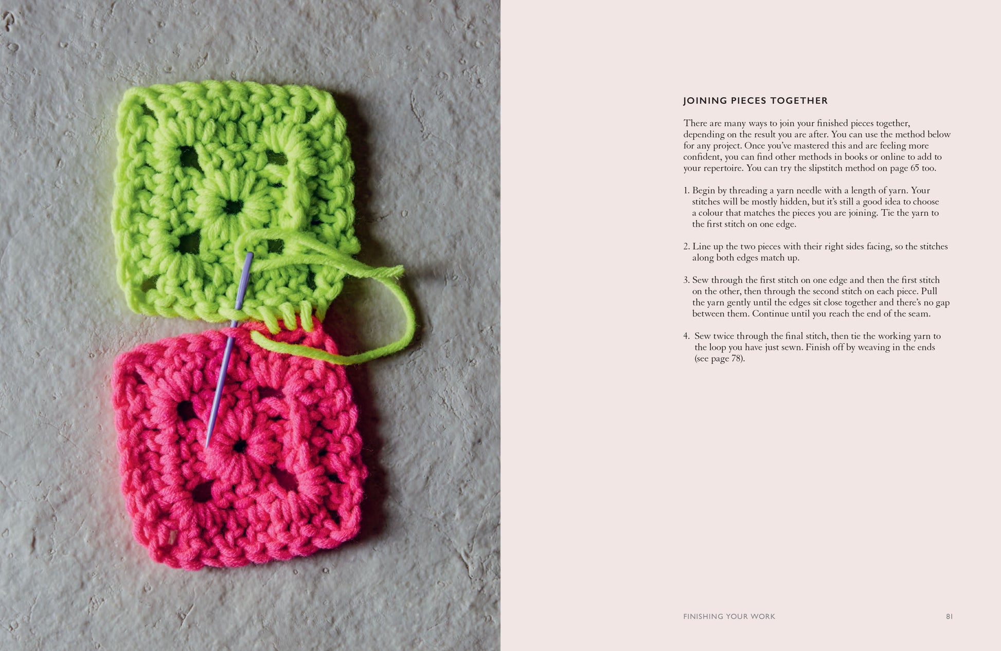 Two crocheted squares, one green and one pink, with a needle on a textured surface.