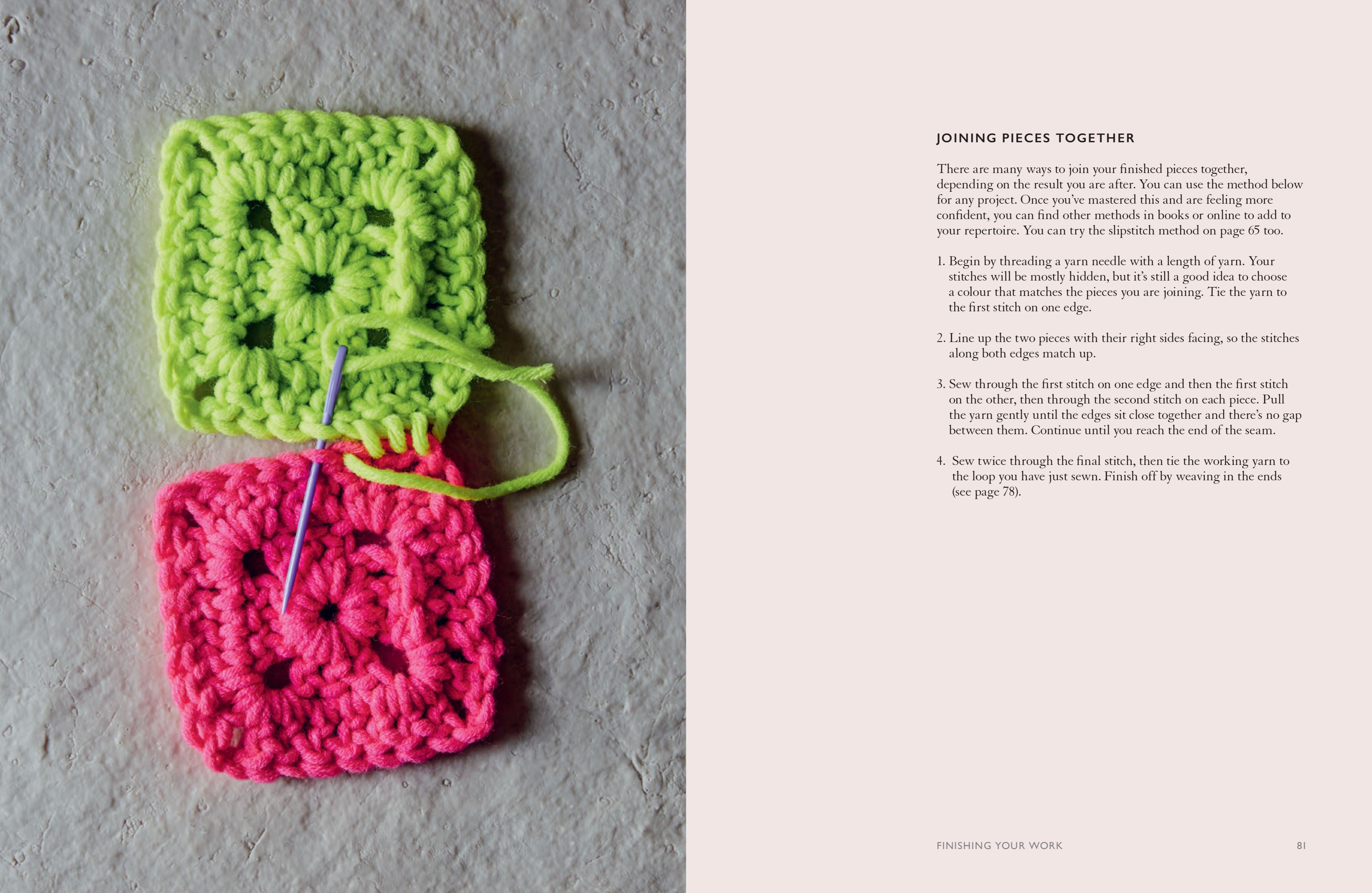 Two crocheted squares, one green and one pink, with a needle on a textured surface.