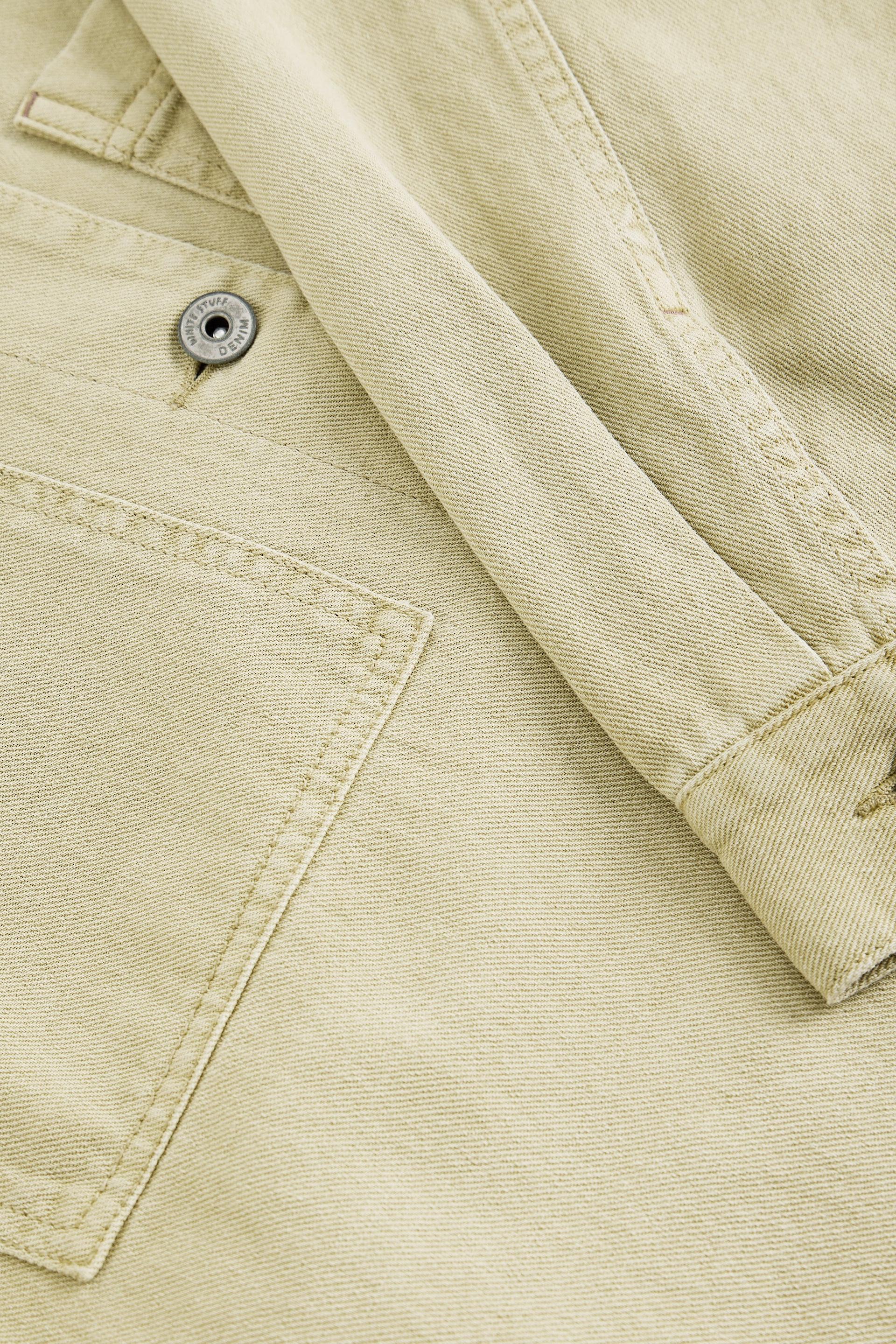 Close-up of beige denim jacket with button details