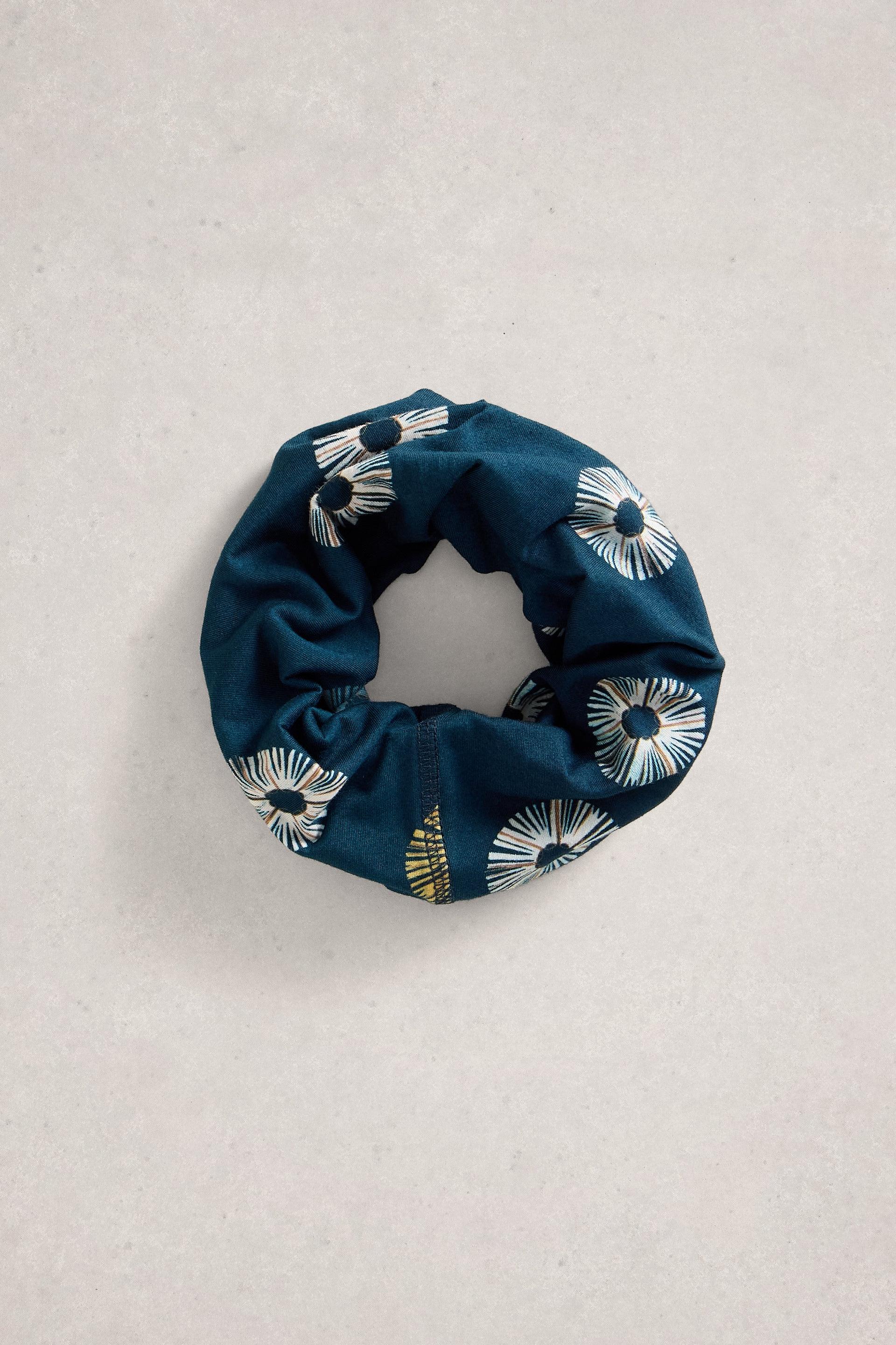 Blue scrunchie with floral pattern on a light gray background