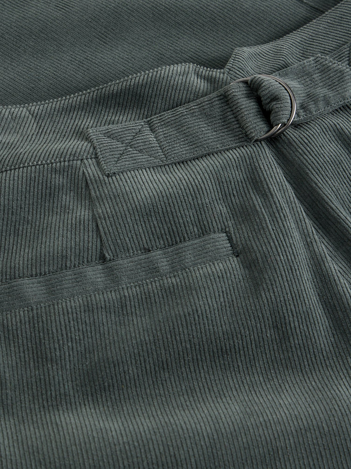 Close up of dark green corduroy women's wide leg trousers with a metal d-ring belt loop detail.