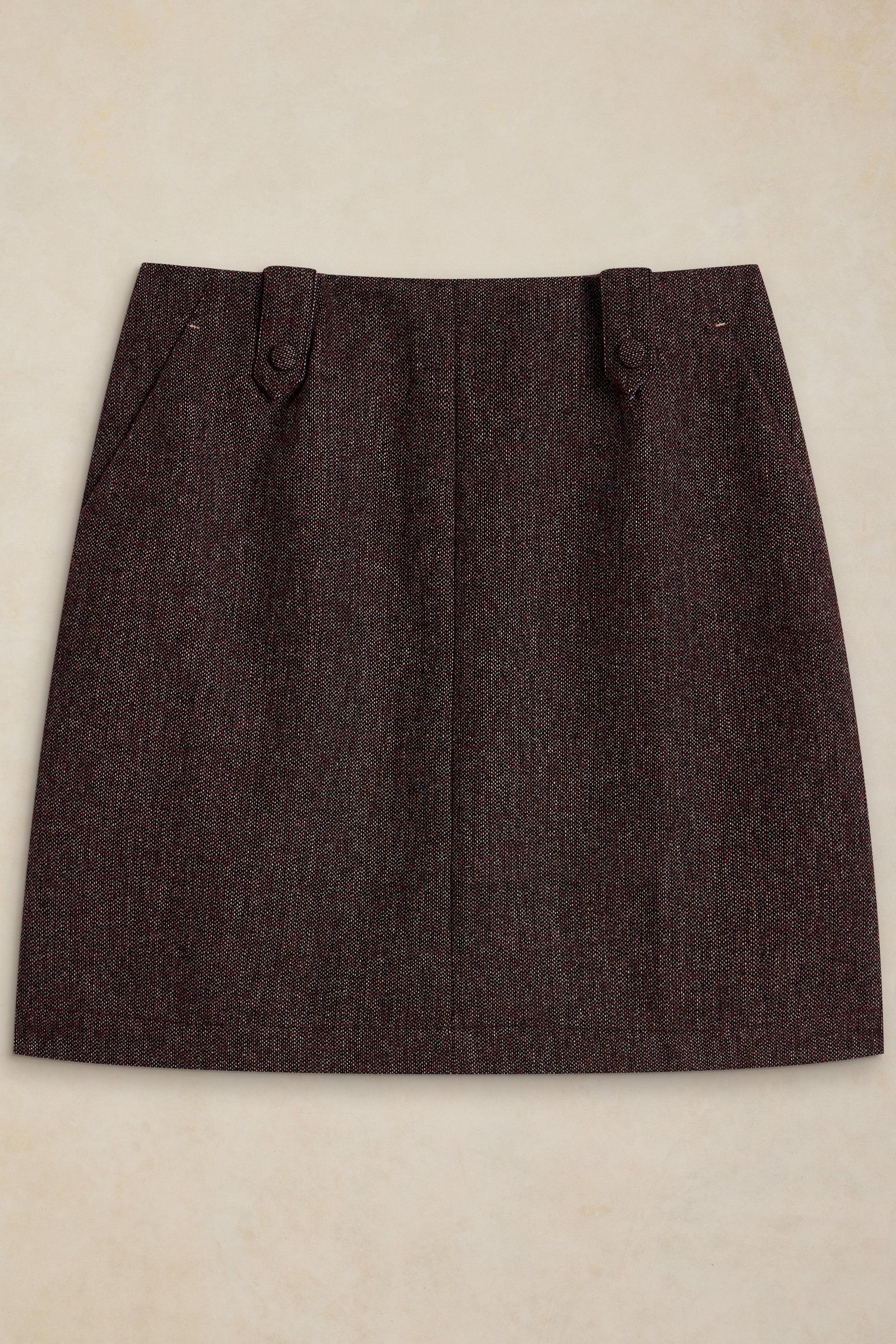 A textured tweed mini skirt with a straight silhouette, laid flat against a light beige background.