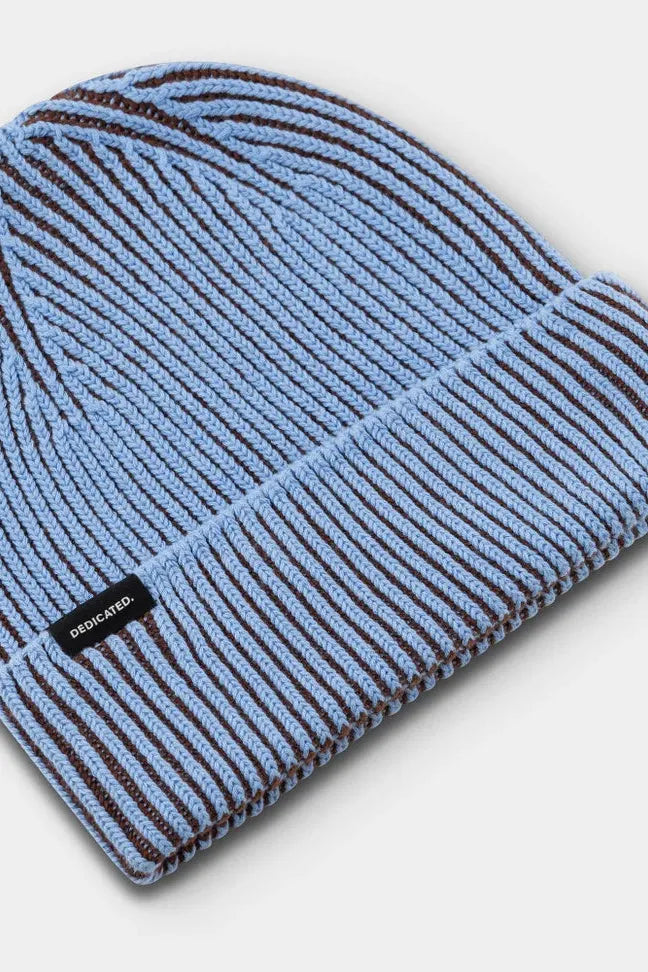 A light blue and brown striped ribbed cotton beanie by Dedicated Clothing on a plain background.