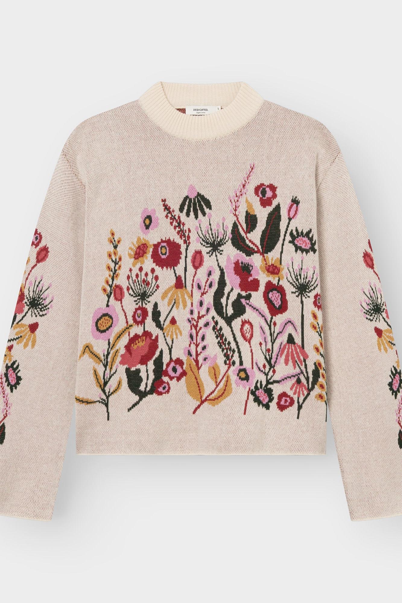 A cream-colored knit sweater featuring a vibrant, multicolored floral and botanical pattern across the chest and sleeves, displayed on a clean light gray background.