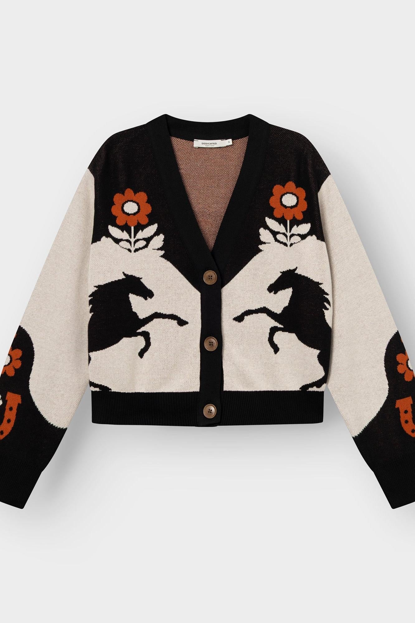 A cropped cardigan sweater with a color-blocked design of black and cream, featuring knitted horse and flower motifs, three front buttons, and long sleeves, shown flat on a light gray background.