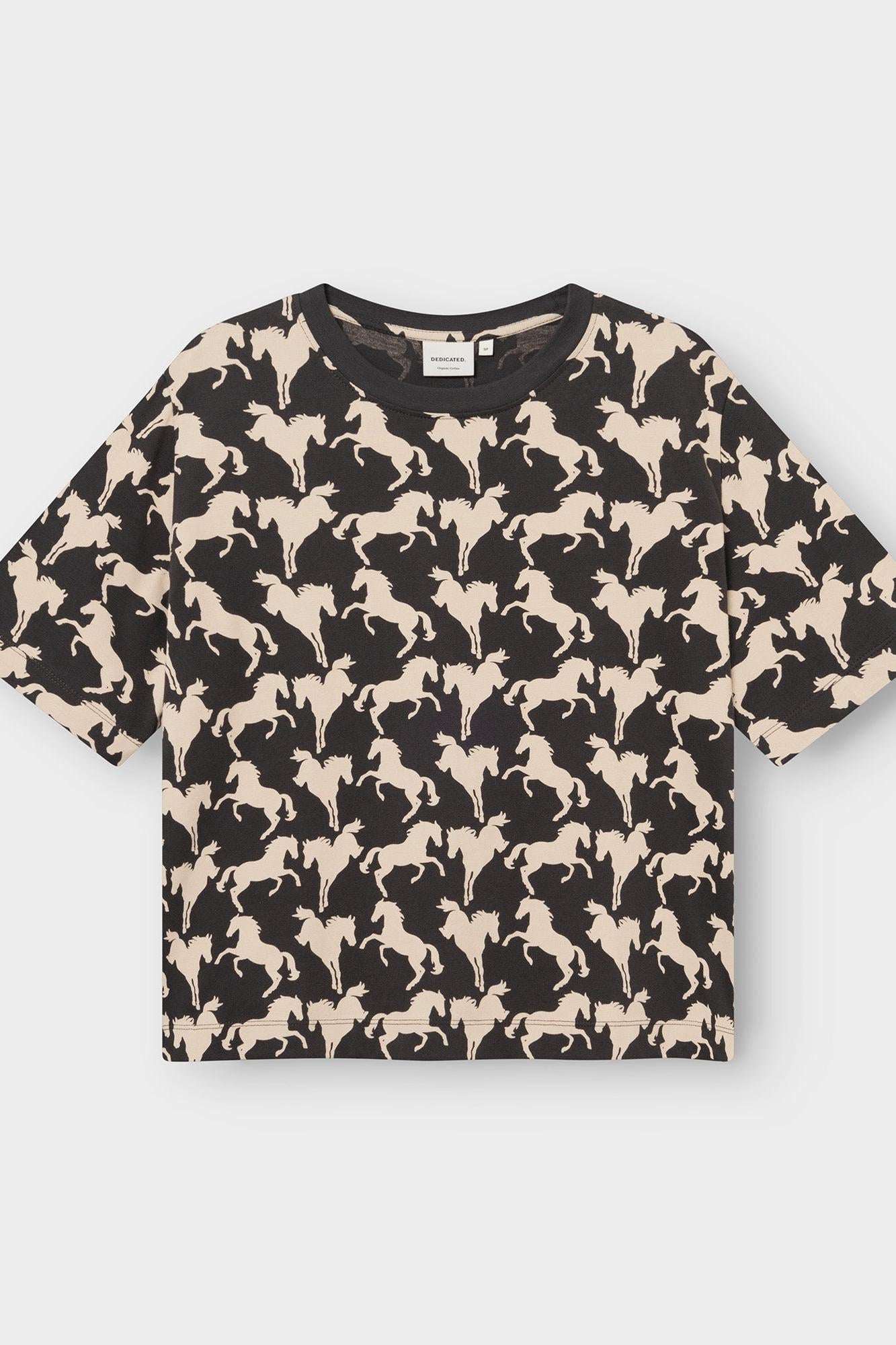 A short-sleeve crewneck t-shirt featuring an all-over repeating pattern of black horse silhouettes on a warm beige background, displayed flat against a light gray studio backdrop.