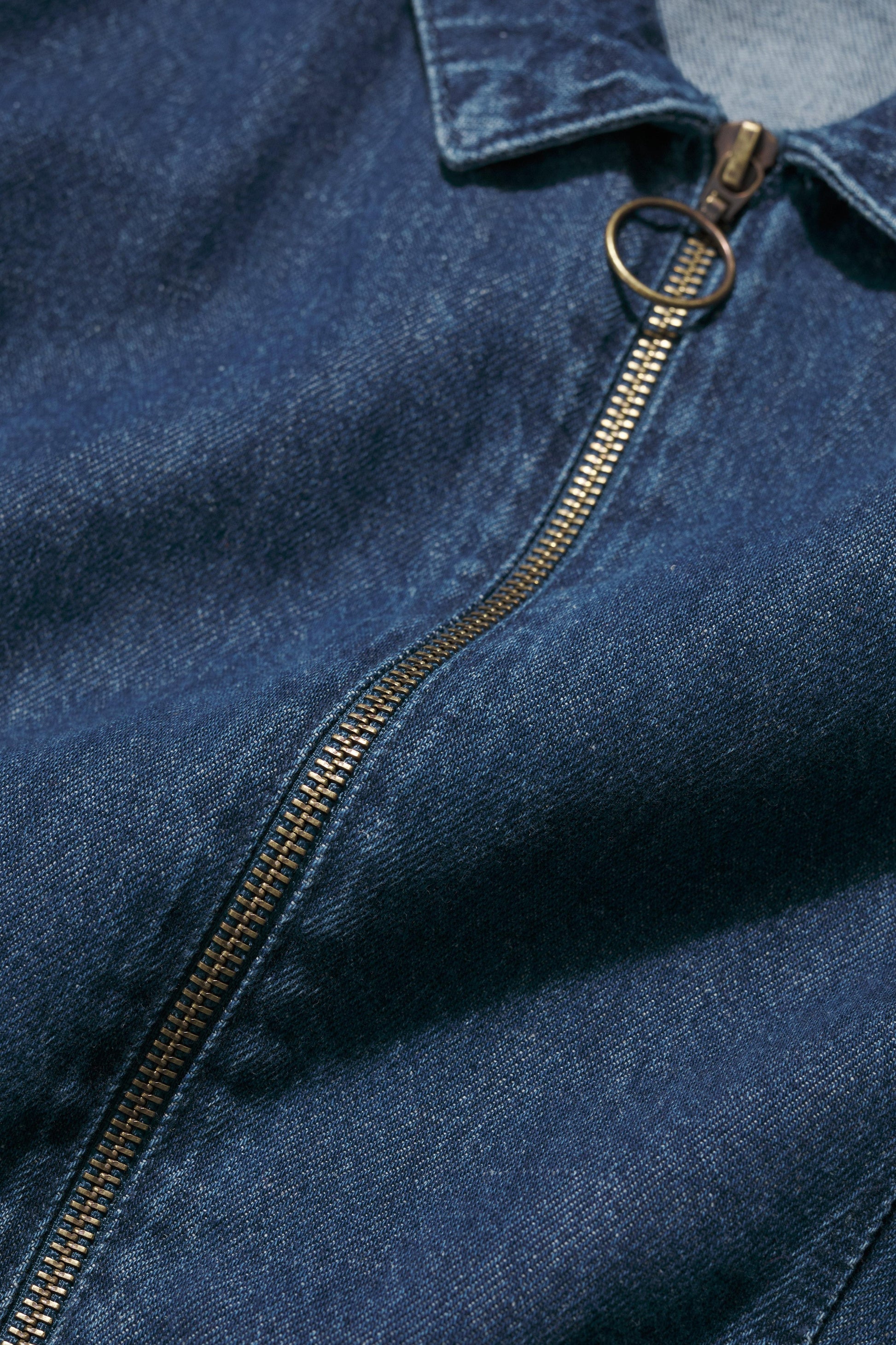 Close-up of a blue denim dress with a zipper