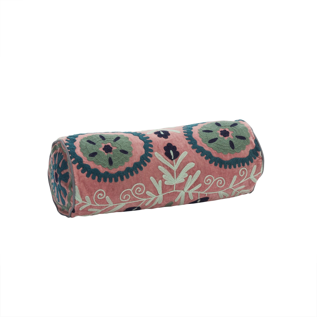 A pink cylindrical bolster cushion with intricate green and dark blue floral embroidery against a white background.