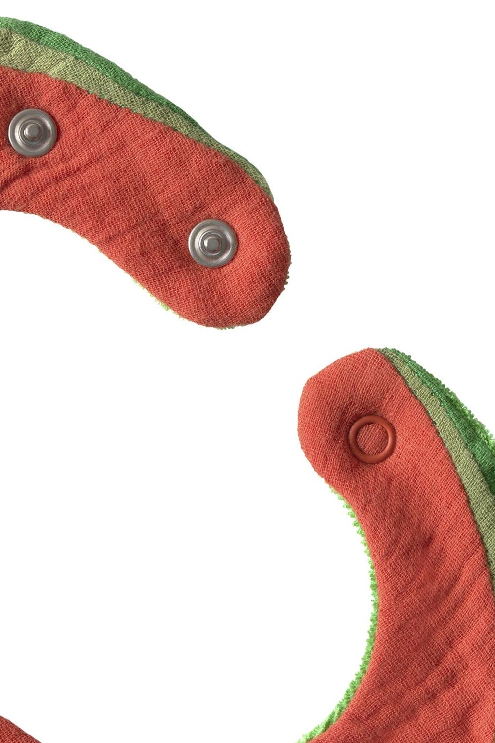 Close-up of red and green bib with metal buttons on a white background