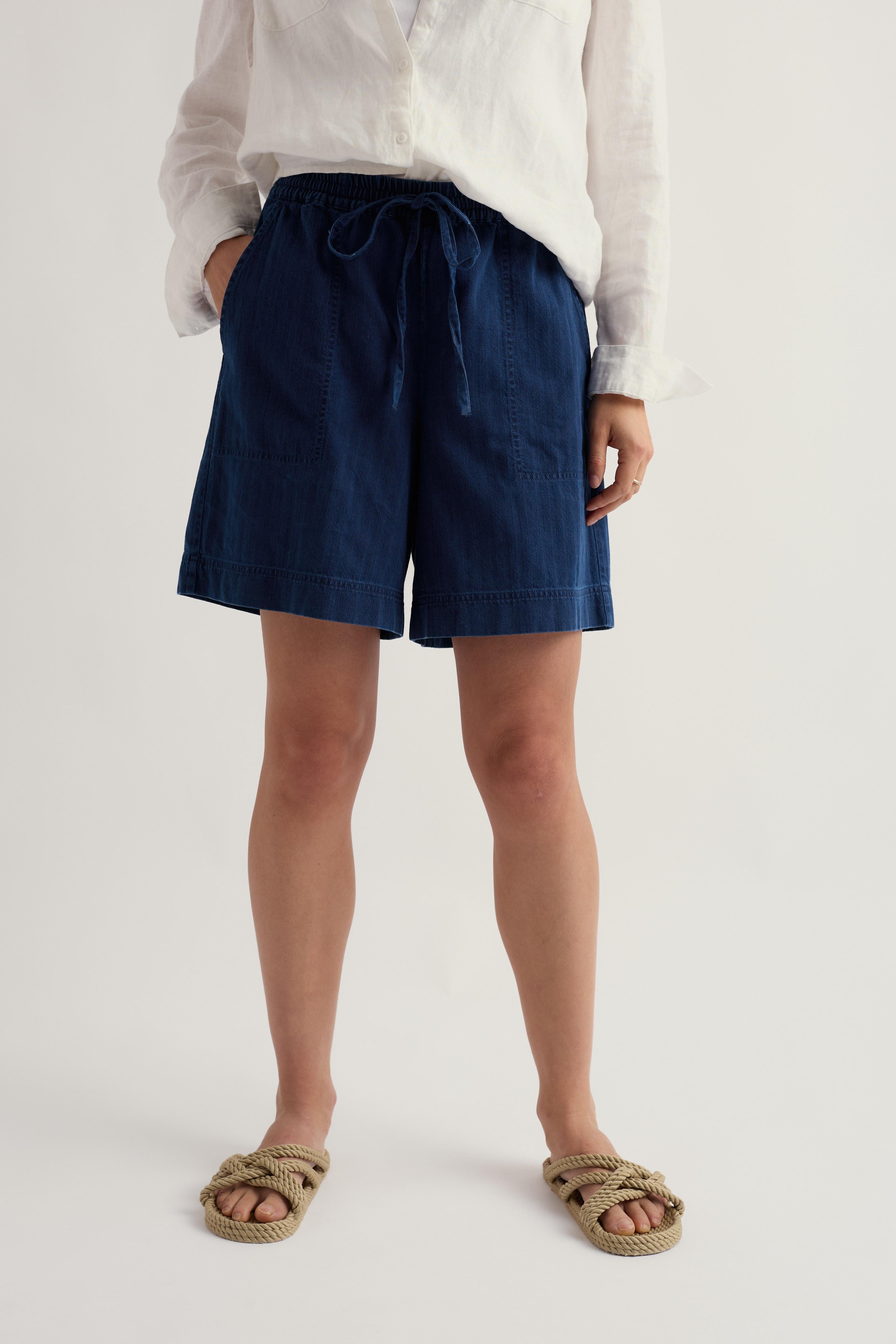 Person wearing navy organic cotton shorts on a white background