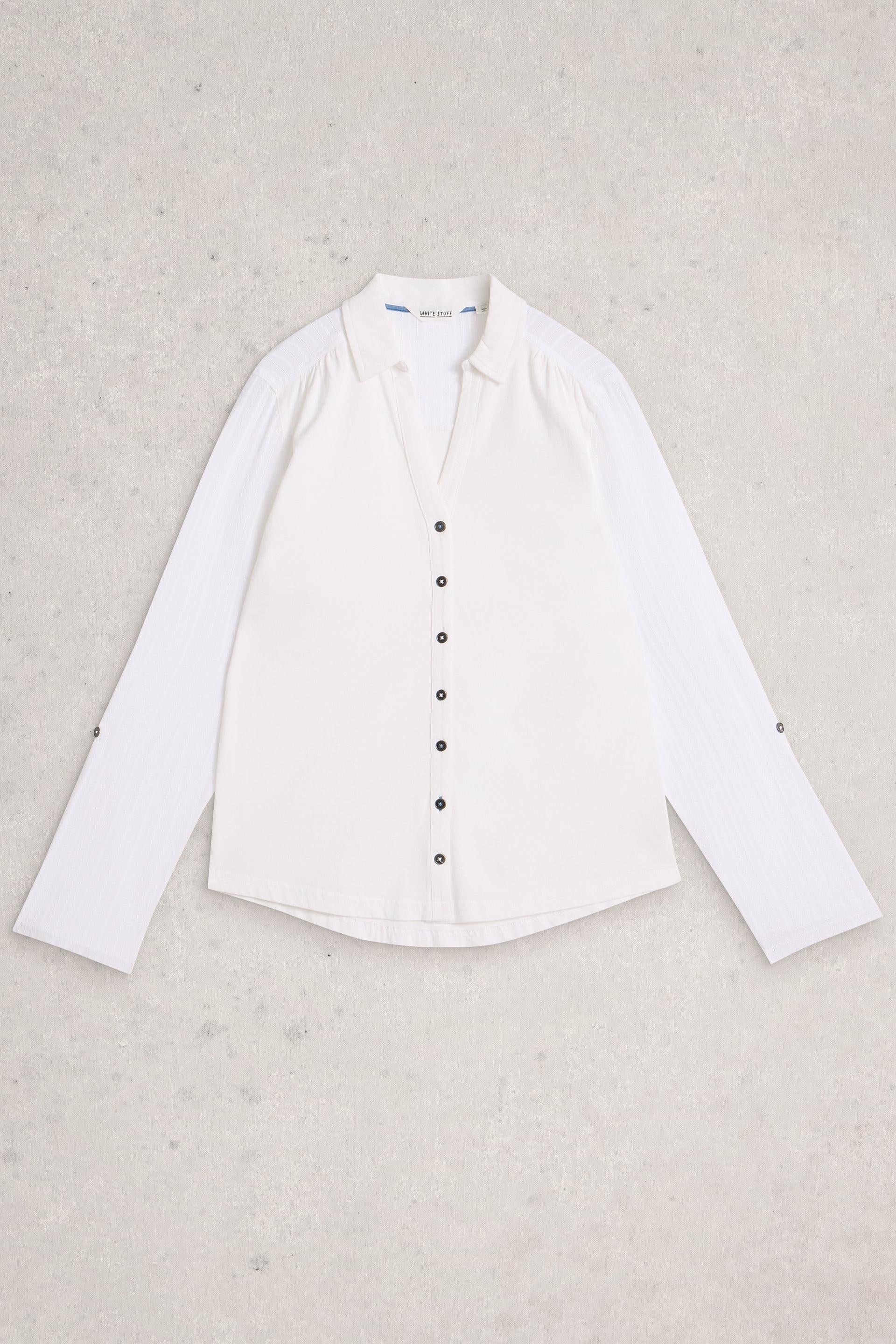 White Stuff shirt with black buttons on a beige background