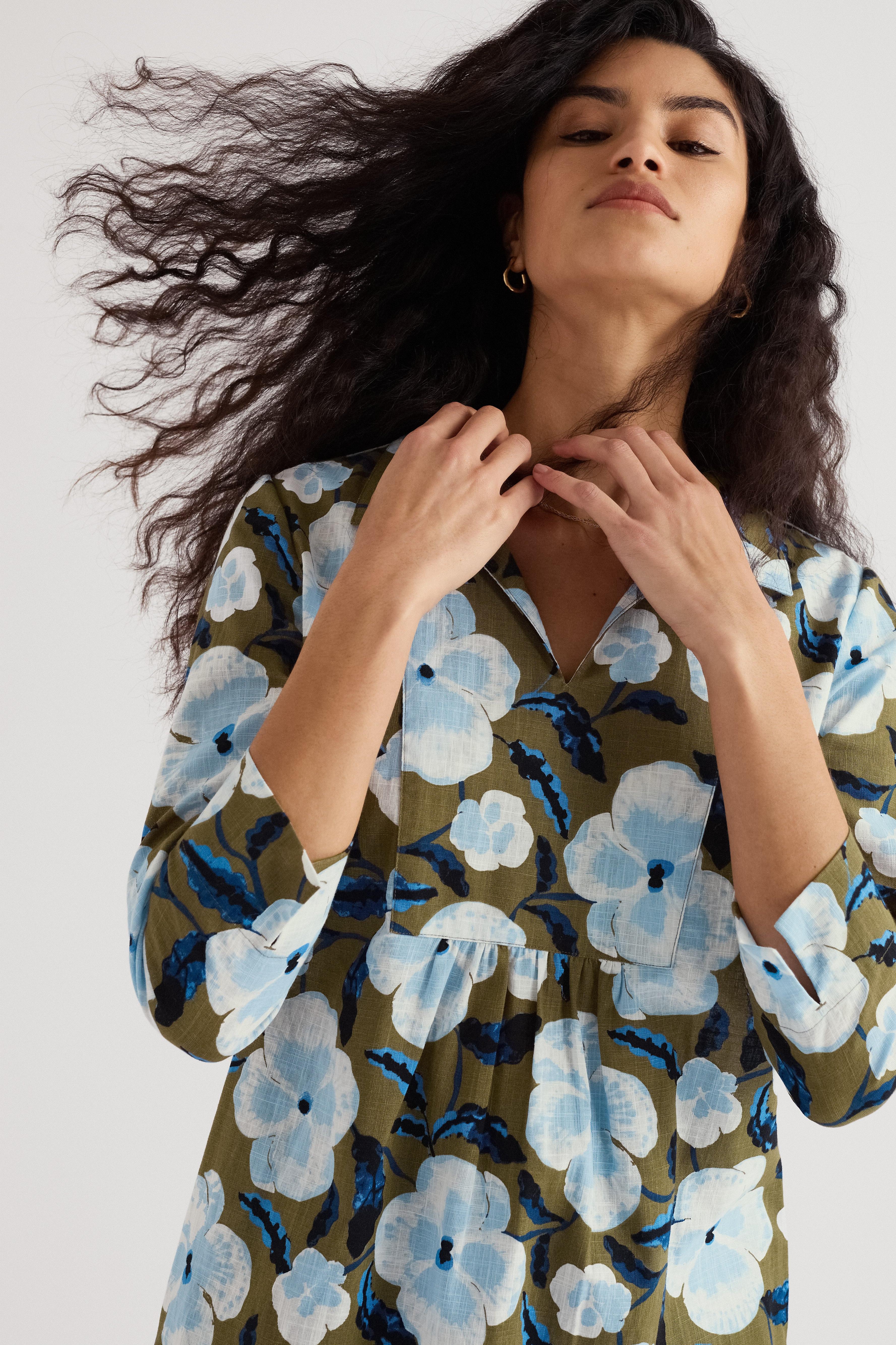 Woman wearing a floral organic cotton tunic with a white background