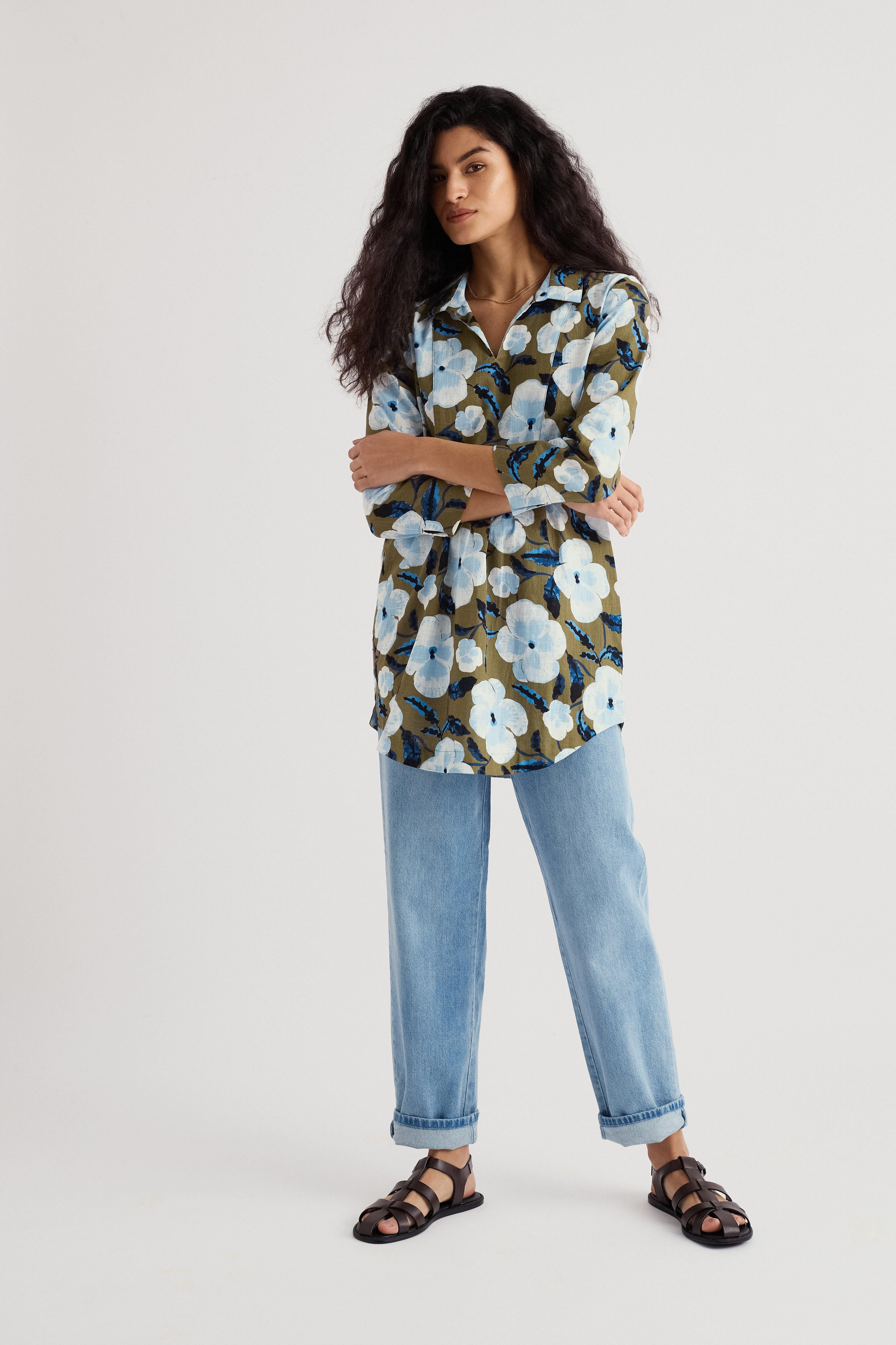 Woman wearing a floral blouse and jeans on a white background
