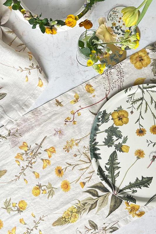 Table setting with floral-patterned plates and cloth napkins on a light surface.