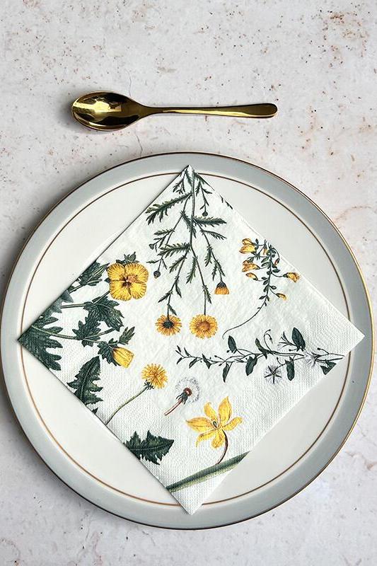 Napkin with floral design on a plate with cutlery on a light background