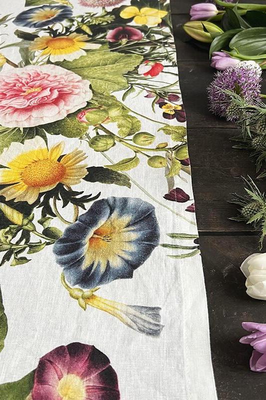 Floral-patterned tablecloth with real flowers on a dark surface