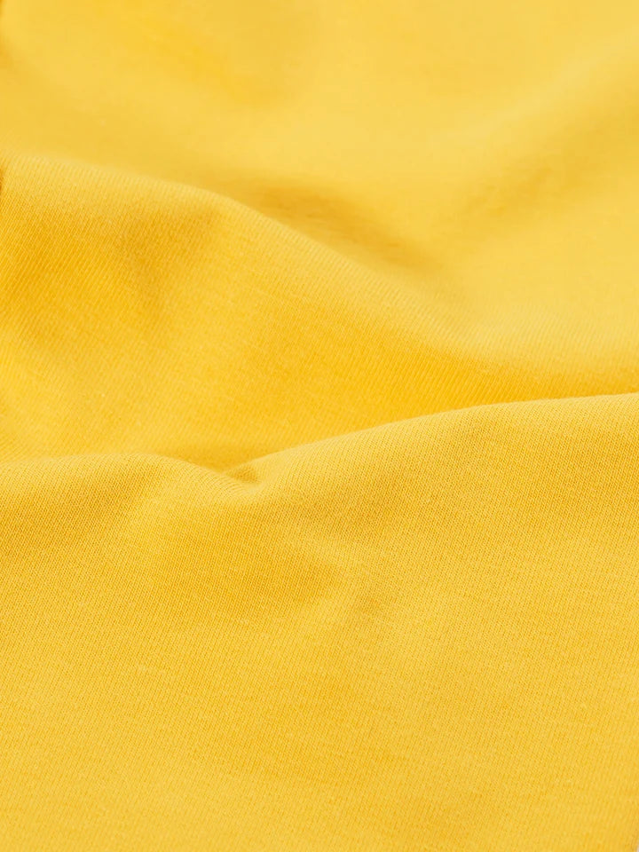 Close-up view of bright yellow organic cotton fabric texture for leggings.
