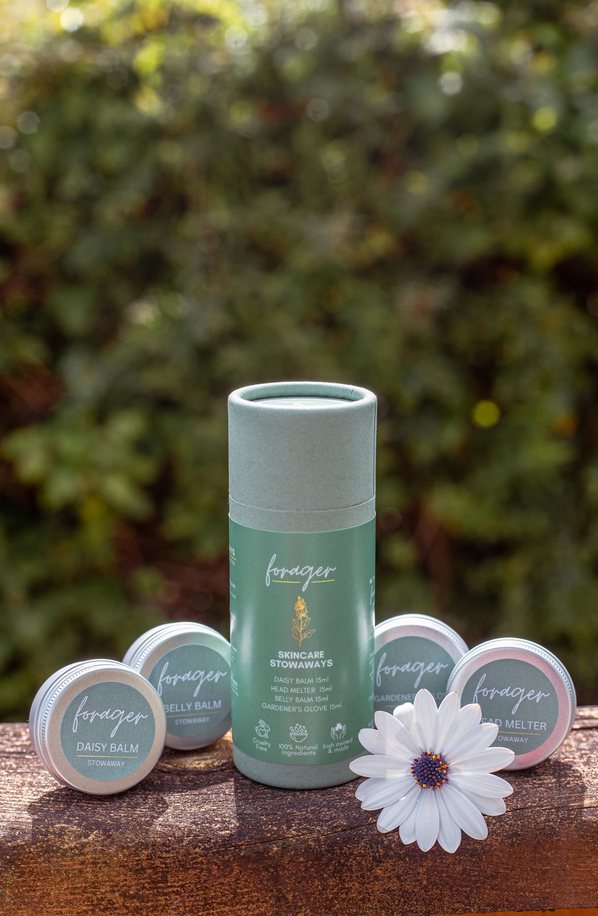 Forager Skincare Stowaways set including Daisy Balm, Belly Balm, Head Melter, and Gardener's Glove tins on wood.