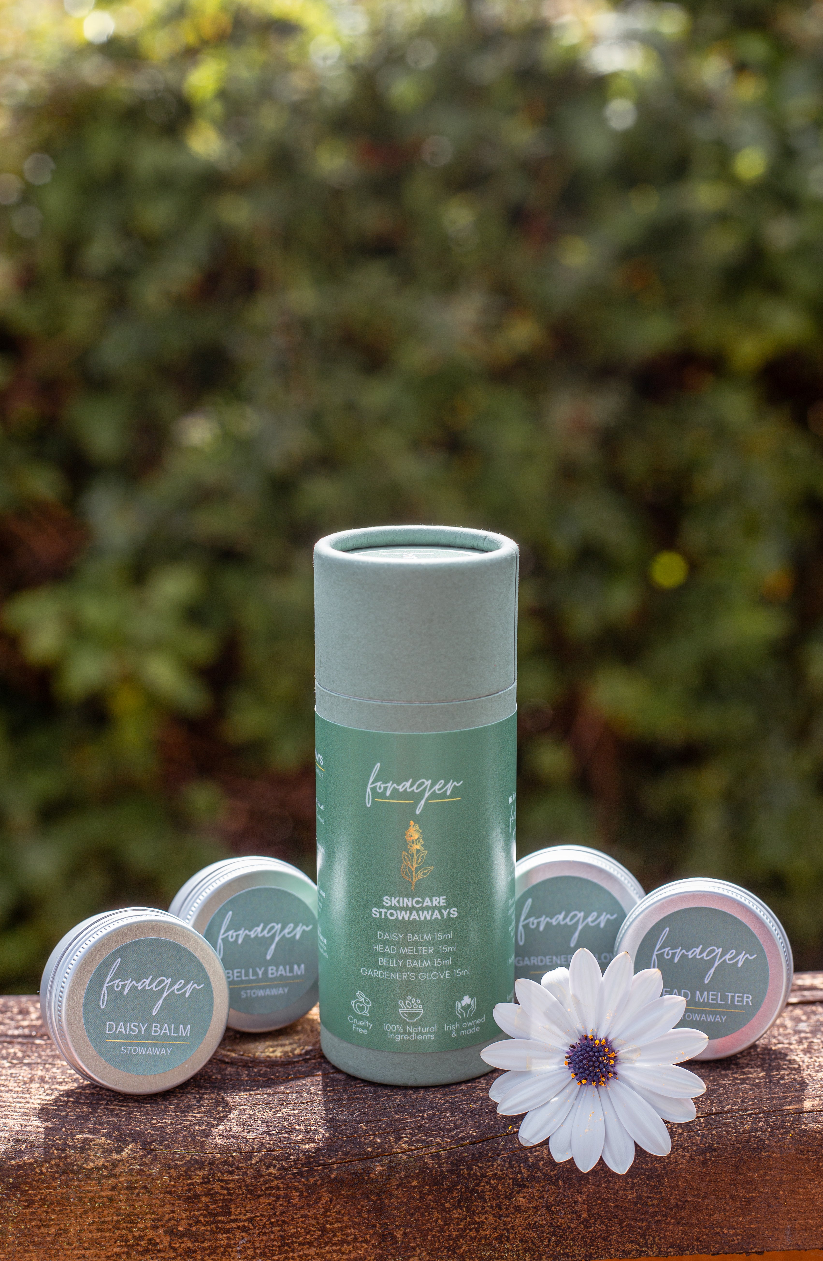 Forager Skincare Stowaways set including Daisy Balm, Belly Balm, Head Melter, and Gardener's Glove tins on wood.