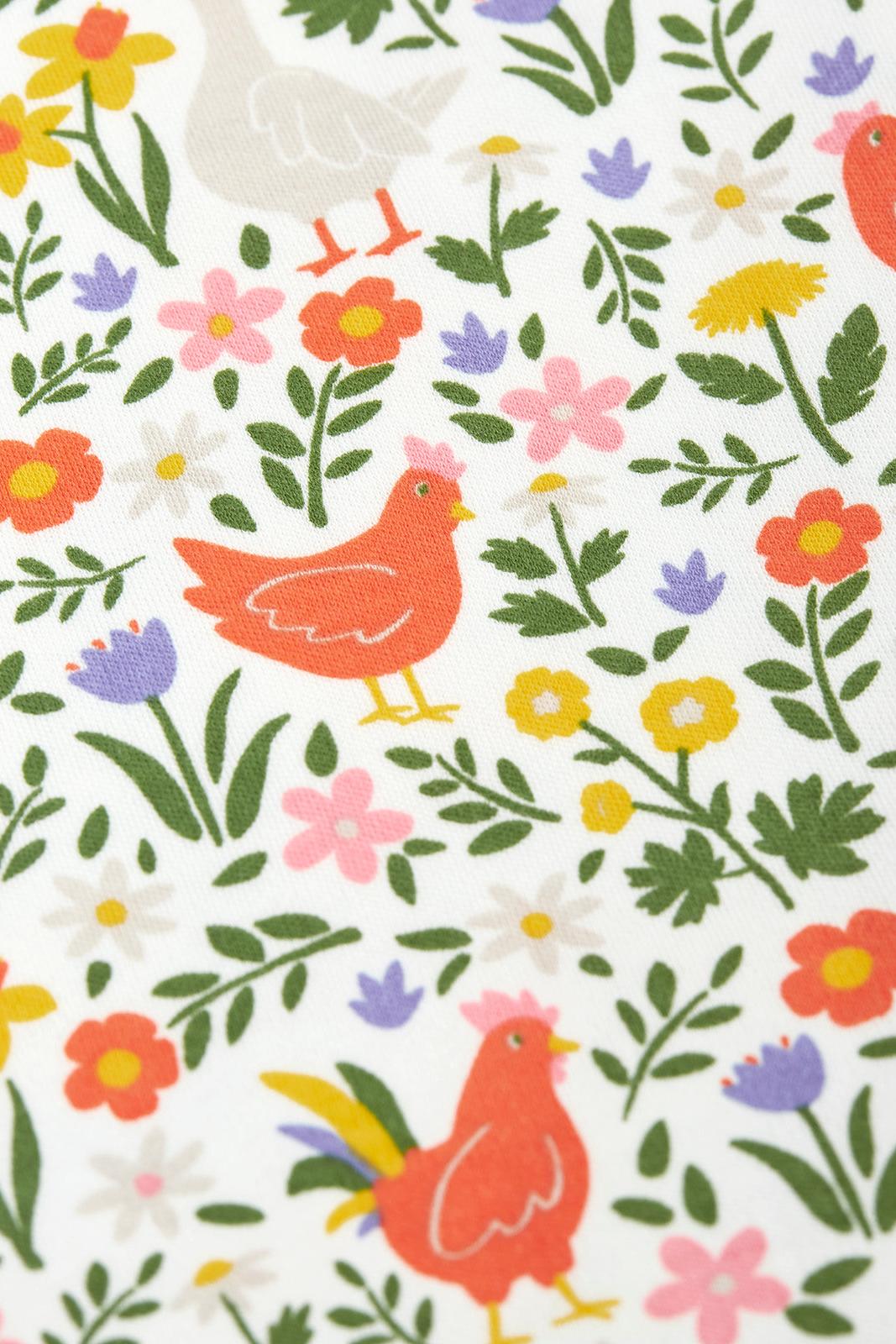Pattern of chickens and flowers on a Frugi babygrow