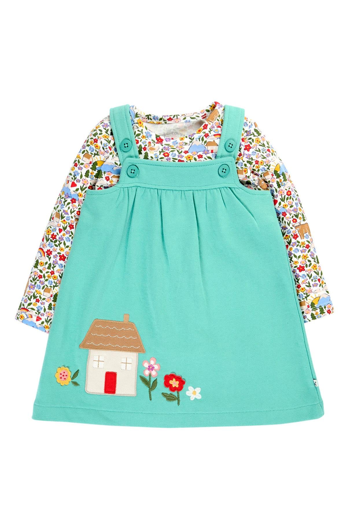 Frugi baby girl outfit in GOTS certified organic cotton, featuring a turquoise pinafore dress with house appliqué and a floral long-sleeved top, ideal as a baby gift.