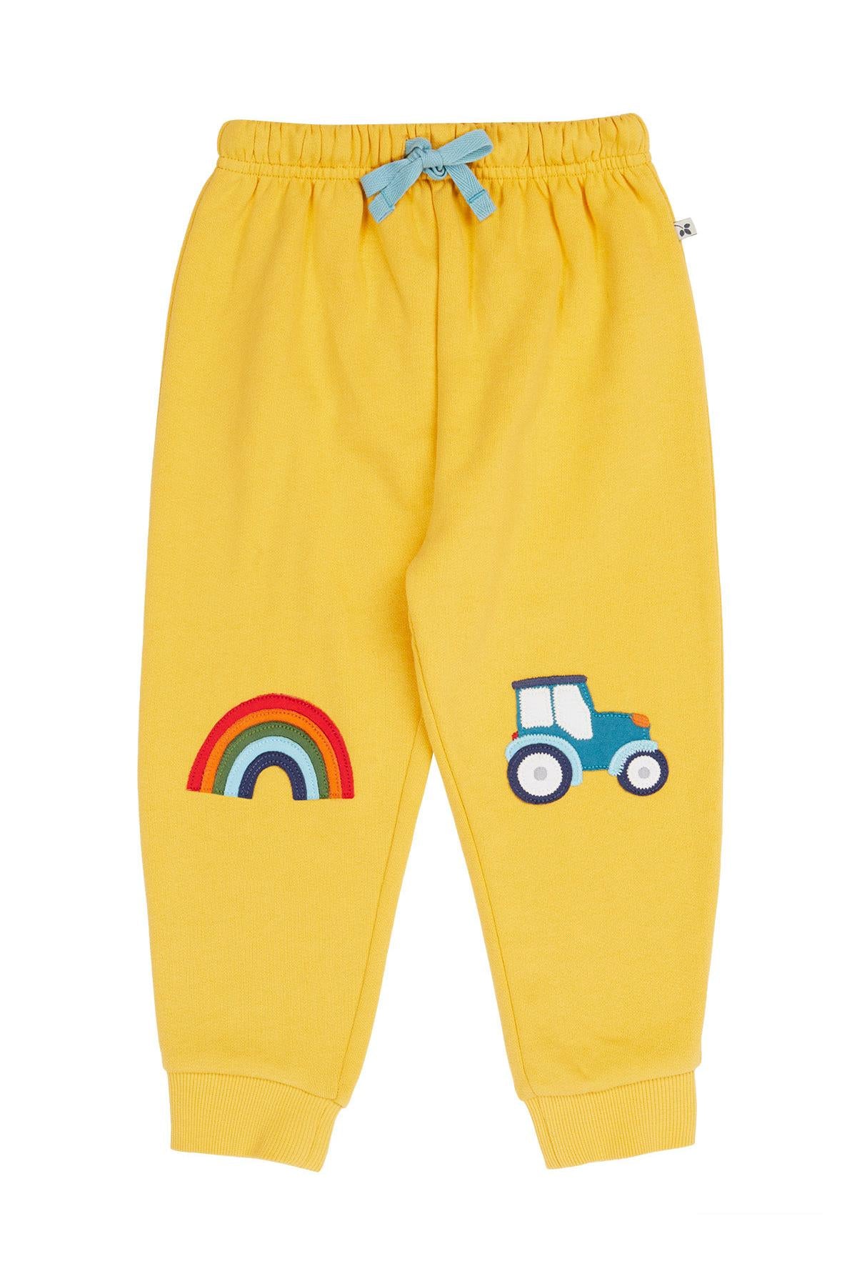 Yellow children's sweatpants with rainbow and tractor design on a white background