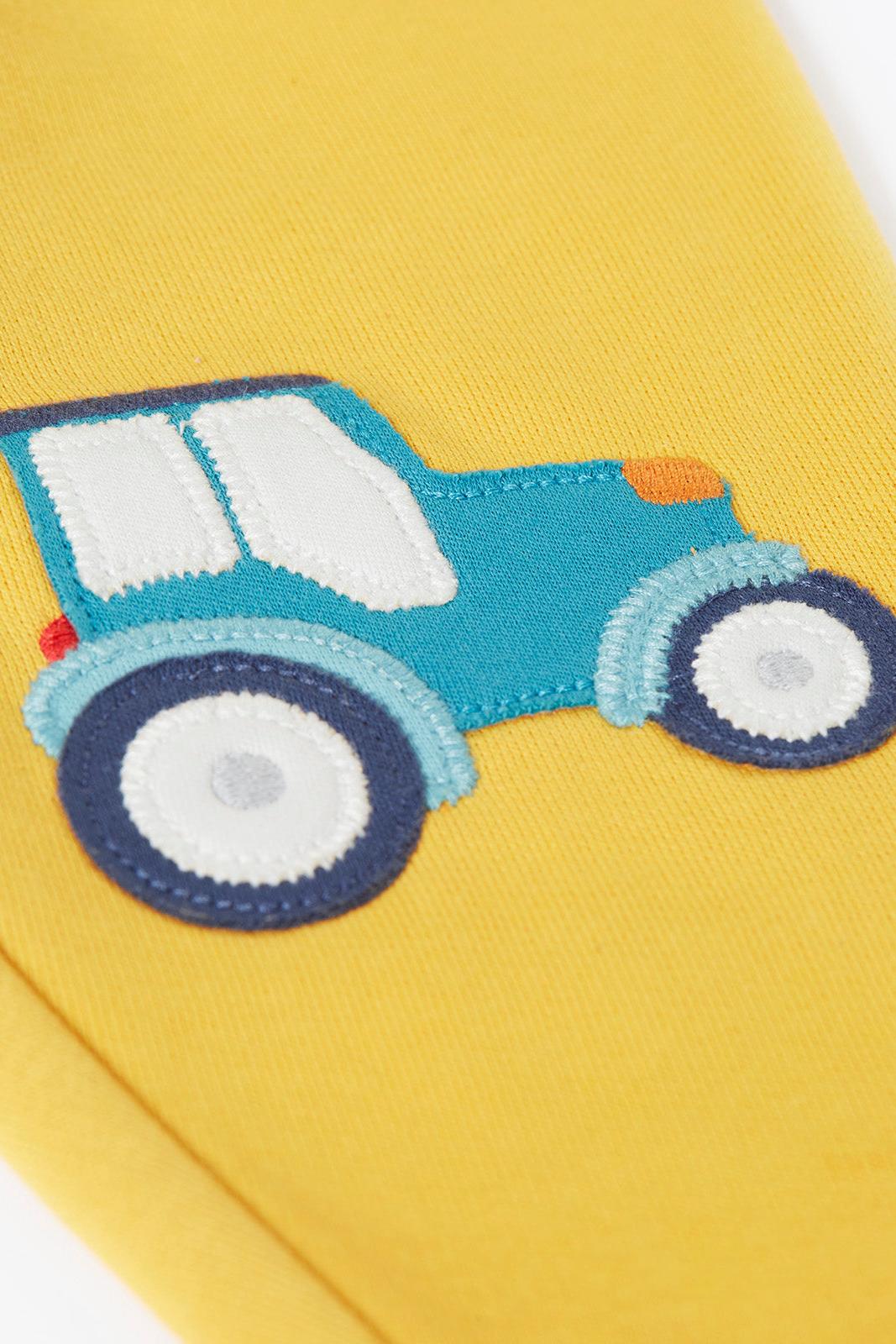 Yellow organic cotton fabric with a blue tractor applique