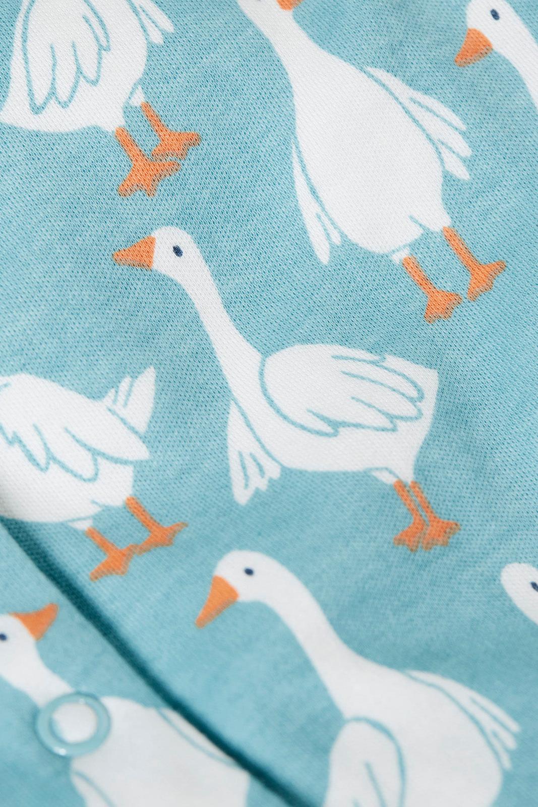 Pattern of white geese with orange feet on a light blue babygrow