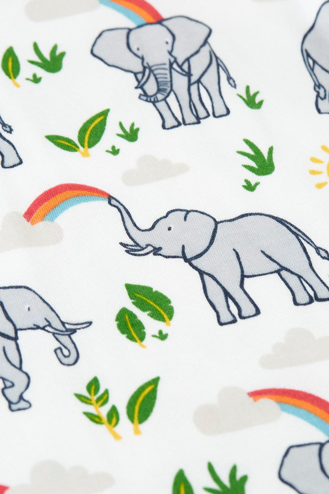 A Frugi fabric print featuring grey elephants, colorful rainbows, suns, and green leaves on a white background.