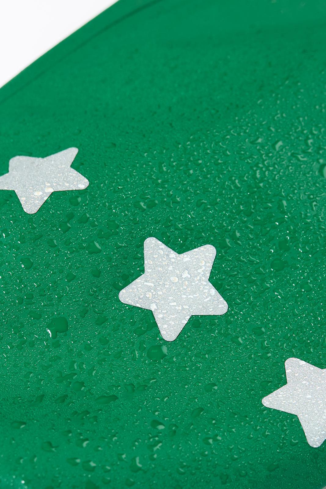 Close-up of a green waterproof Frugi fabric with reflective star details covered in raindrops