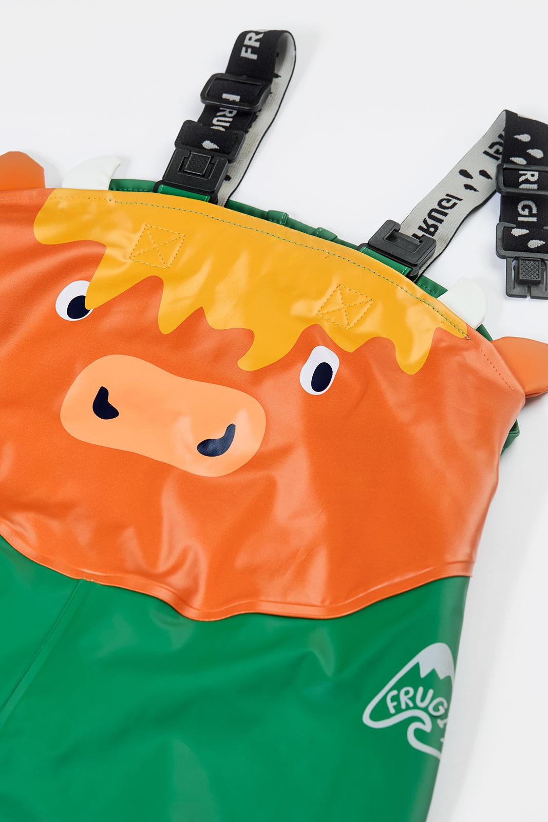 Frugi children's waterproof dungarees featuring a cute orange highland cow face design against a green background
