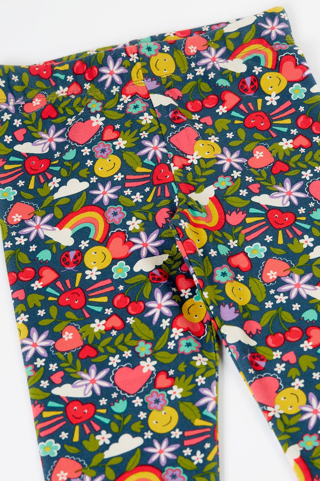Colorful patterned fabric with hearts, flowers, and rainbows on a dark background
