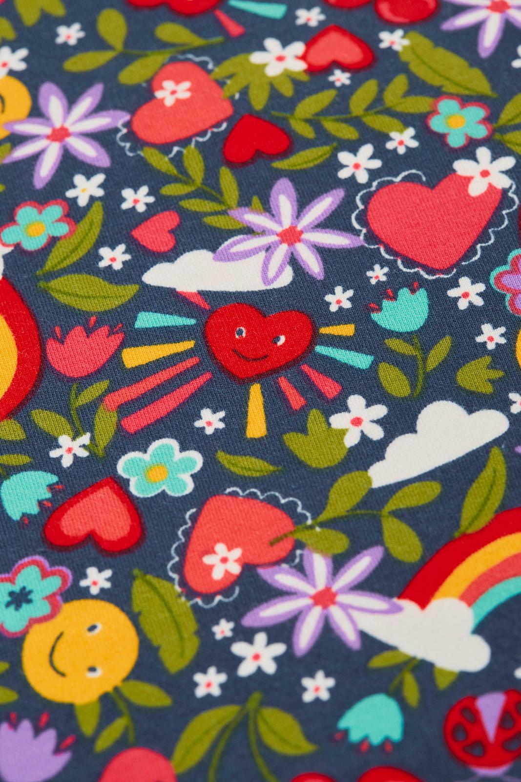 Colorful fabric pattern with hearts, flowers, and rainbows on a dark blue background