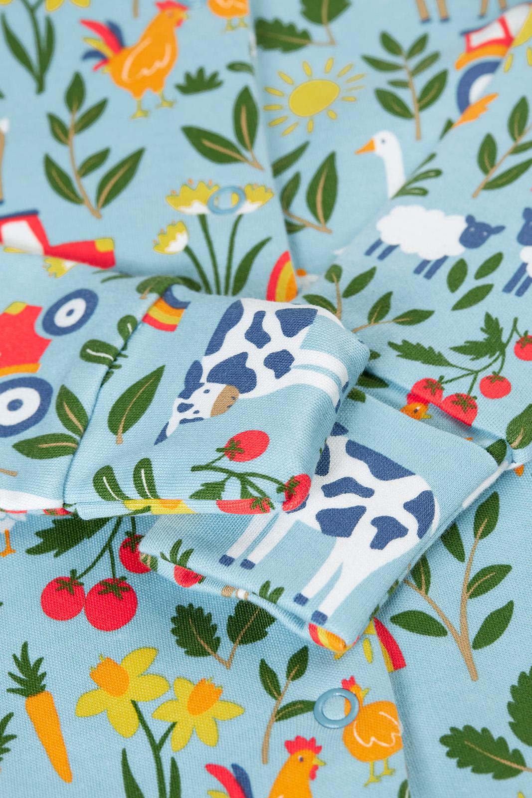 Children's organic cotton fabric with farm animal and nature patterns on a blue background