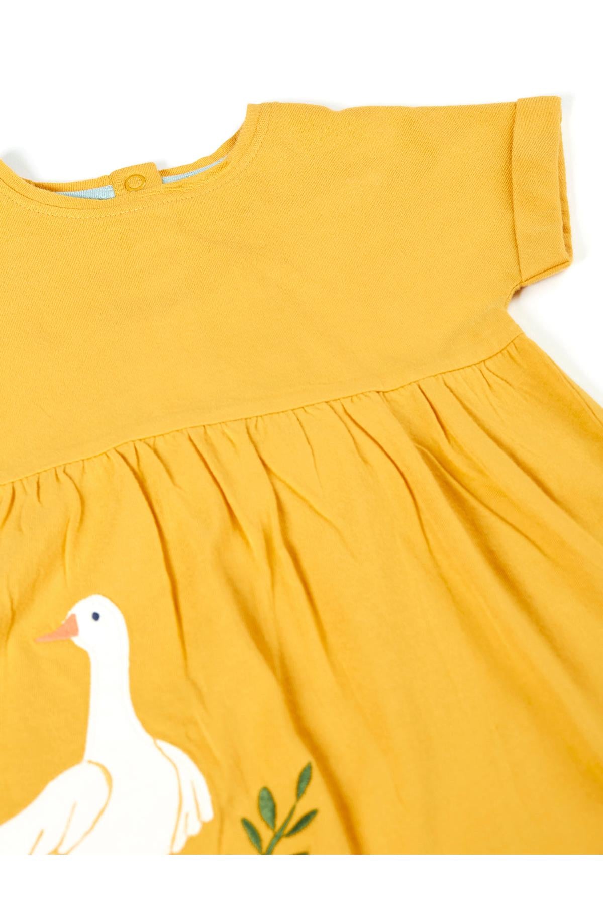 Yellow Frugi top with a duck design on a white background