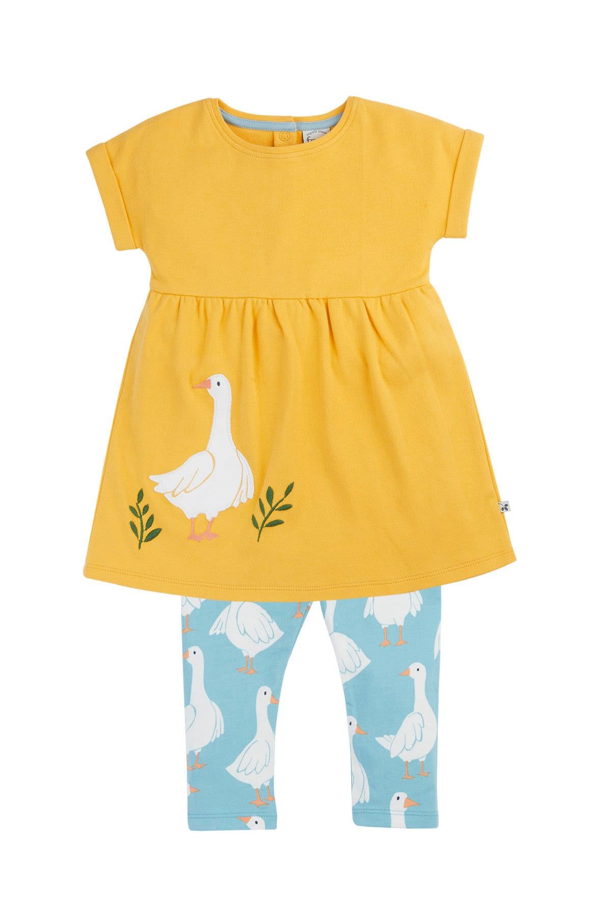 Yellow Frugi dress with duck design and blue leggings with duck pattern on a white background