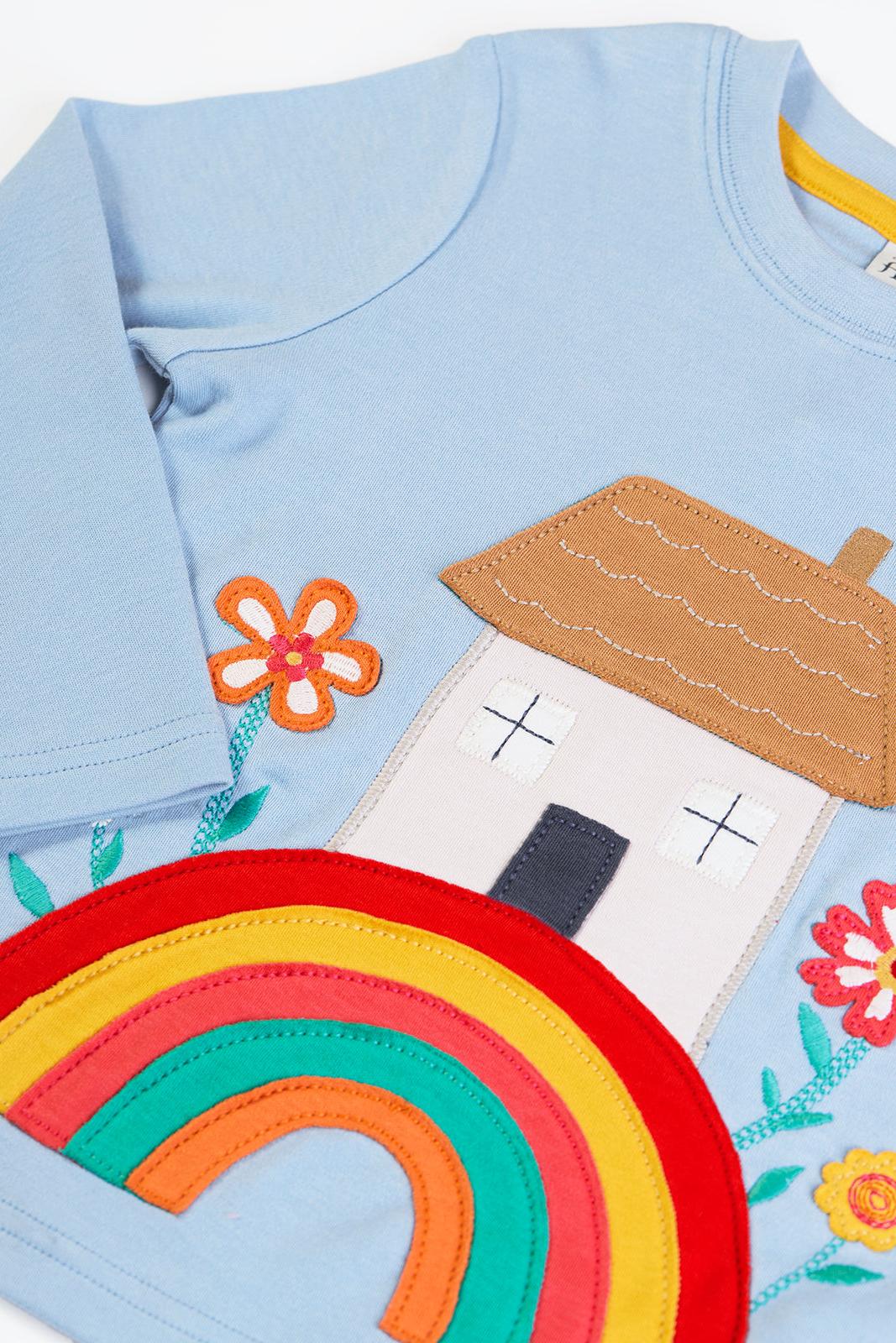 Light blue Frugi organic cotton baby girl top with a colourful house, rainbow, and flower applique design.