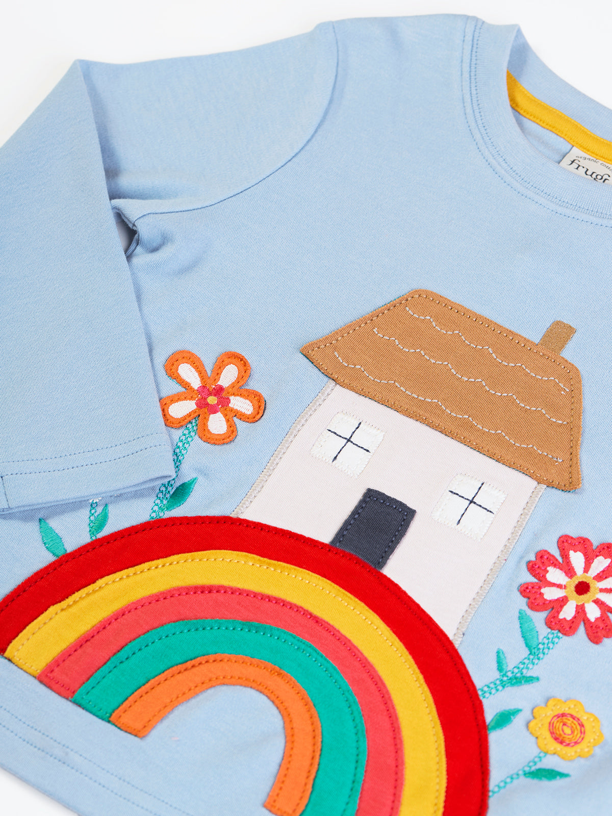 Light blue Frugi organic cotton baby girl top with a colourful house, rainbow, and flower applique design.