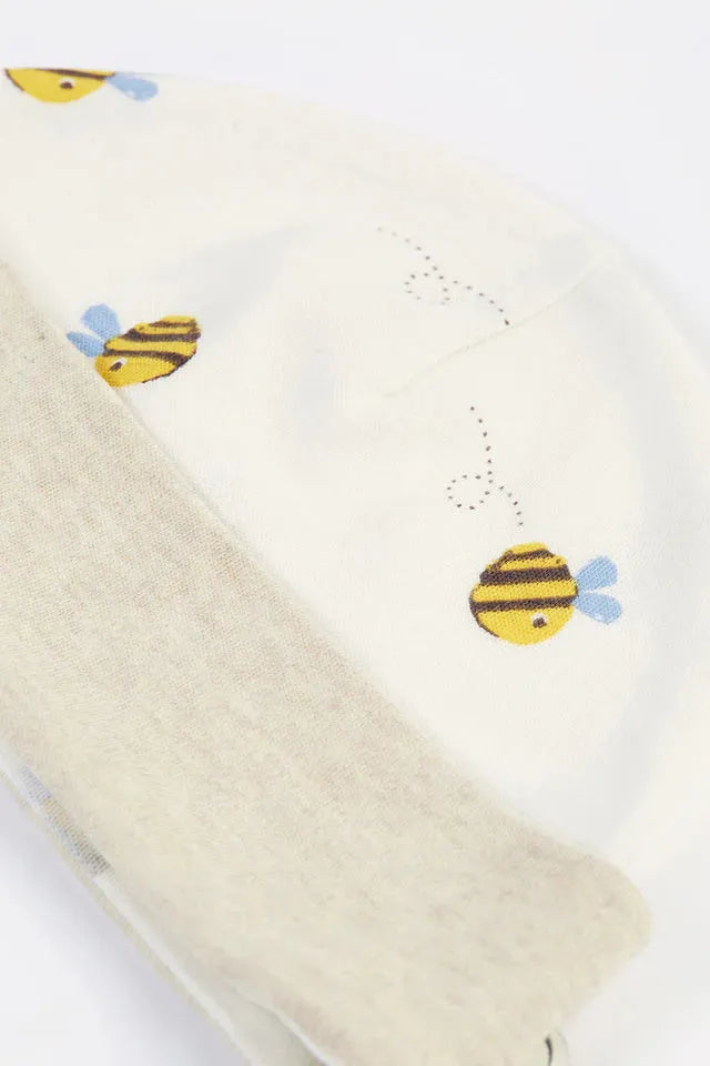 Close up of a cream baby hat made of organic cotton featuring a small bee print pattern