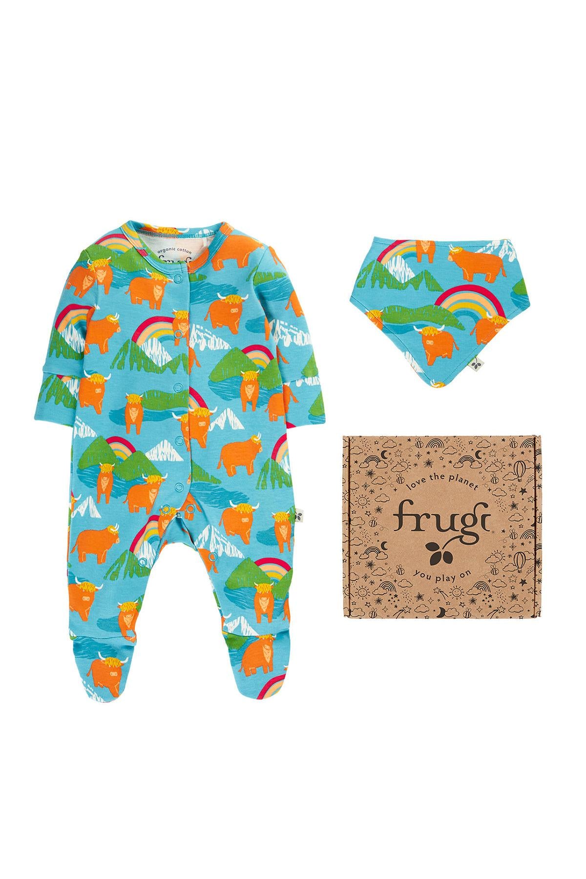 Frugi organic cotton babygro and bib gift set featuring a colorful farm cow and rainbow pattern against a white background.