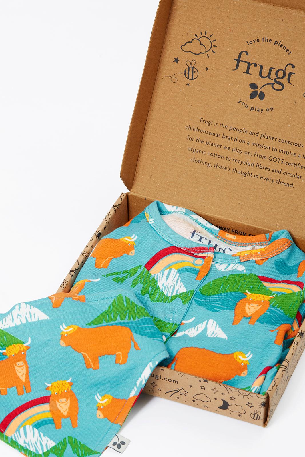 Frugi organic cotton babygro and bib gift set with cow and rainbow print in a cardboard box.