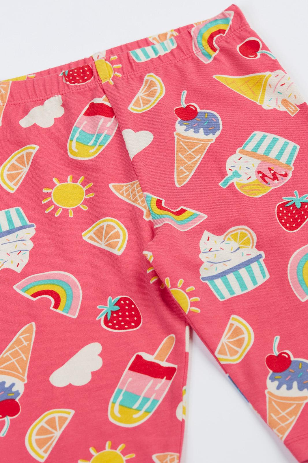 Pink children's shorts with ice cream, rainbow, and fruit patterns on a white background