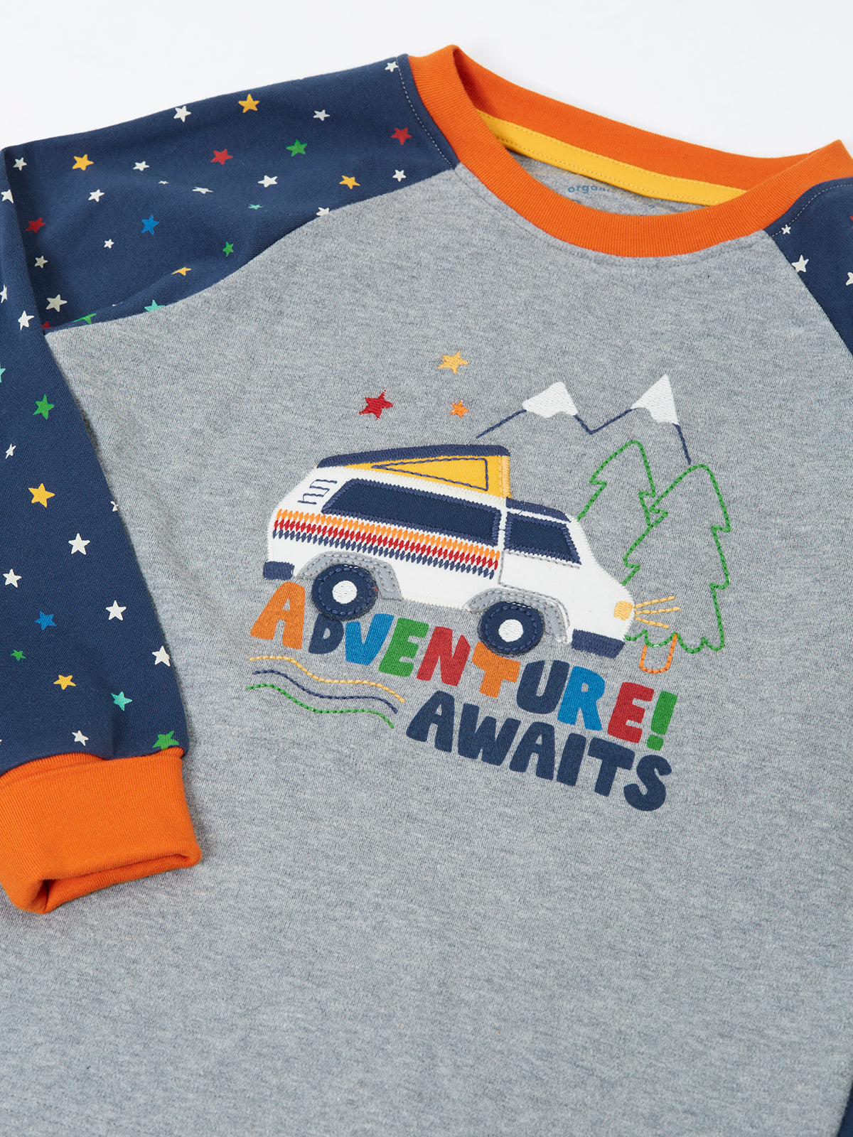 Close-up of Frugi organic cotton pyjamas featuring a camper van and Adventure Awaits text