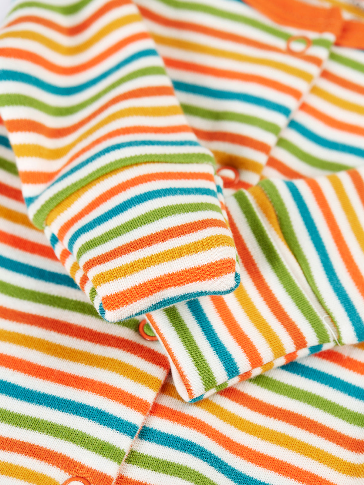 A close-up view of a Frugi organic cotton babygro with a vibrant multicolored stripe pattern.