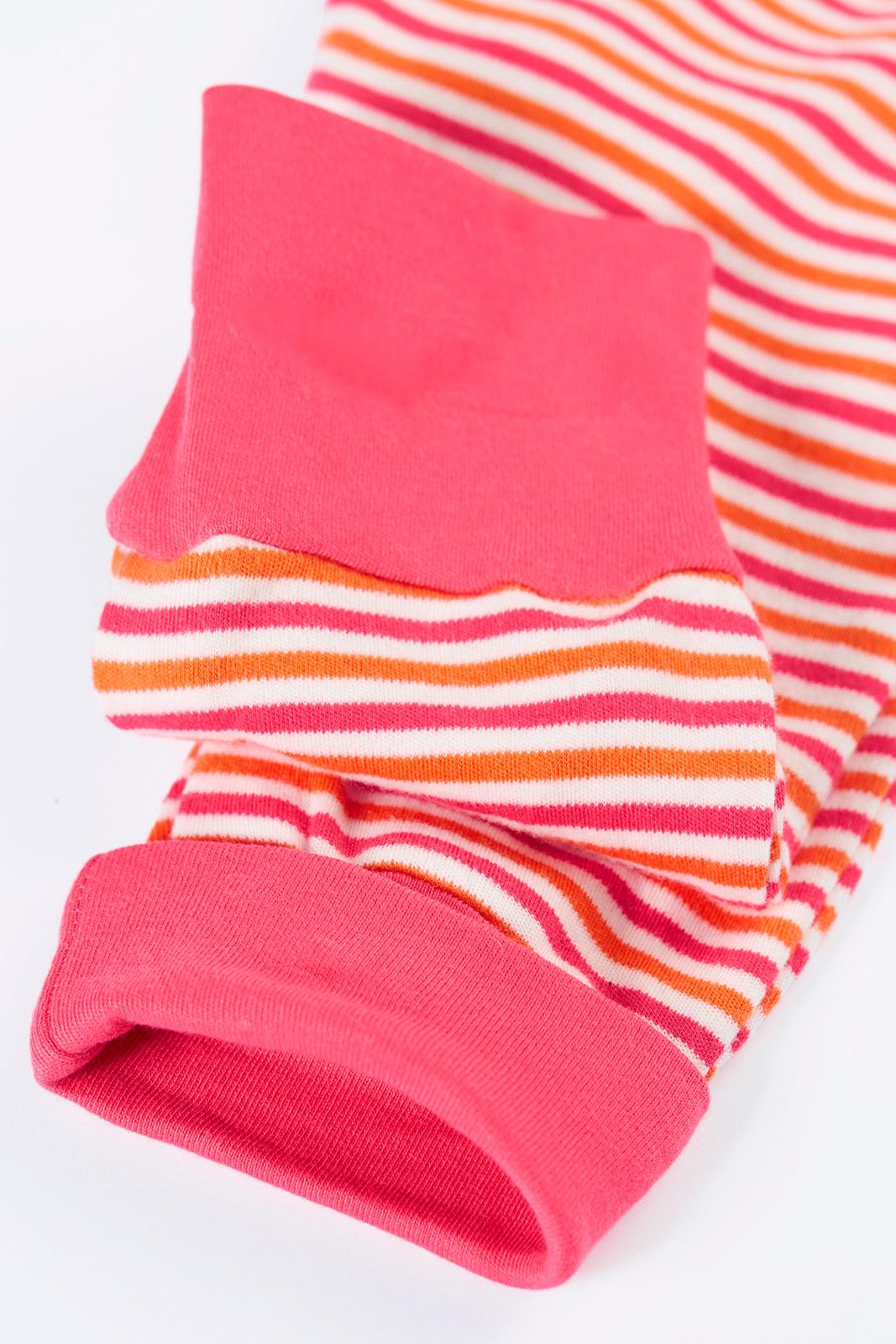 Close up of folded organic cotton babygro with pink and orange stripes and solid pink cuffs.