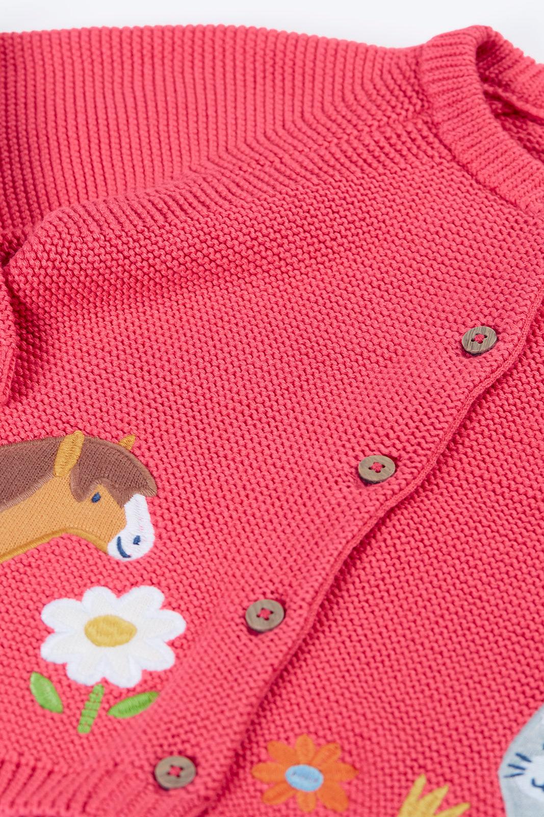 A Frugi organic cotton girls pink cardigan featuring an embroidered horse and flower design.