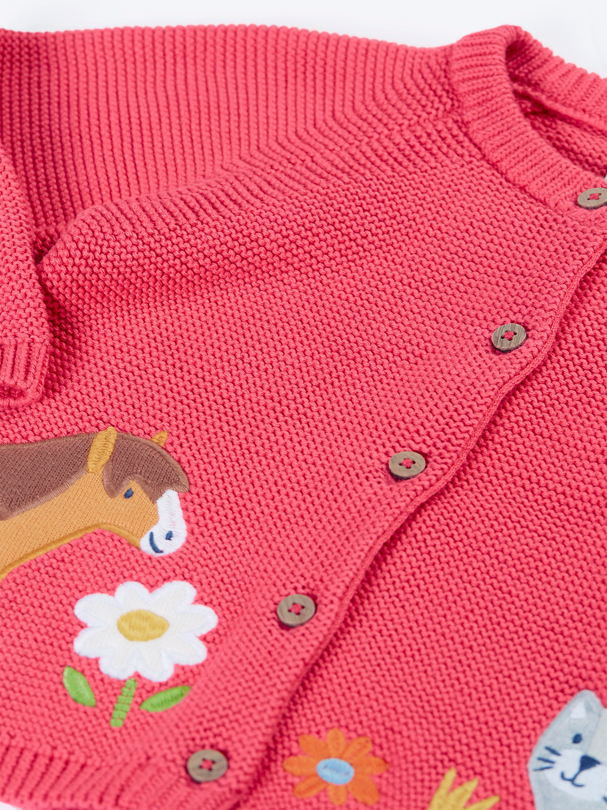 A Frugi organic cotton girls pink cardigan featuring an embroidered horse and flower design.