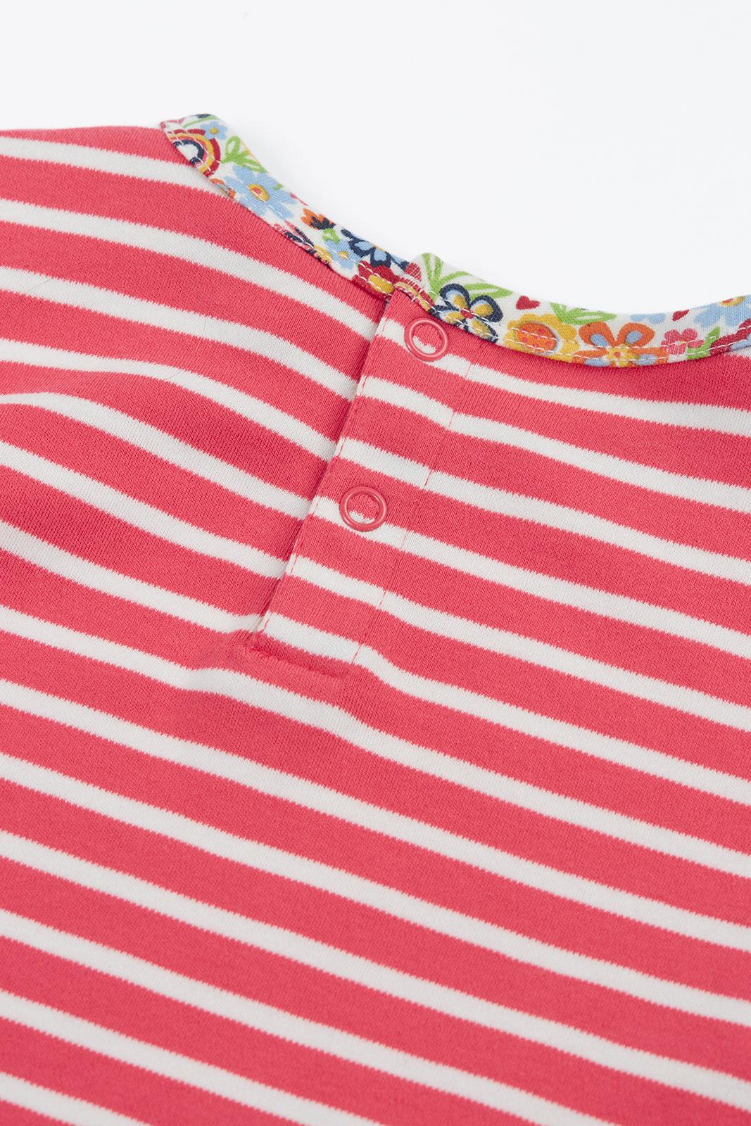 Close-up of a Frugi organic cotton pink and white striped girls t-shirt with floral trim and snap buttons.